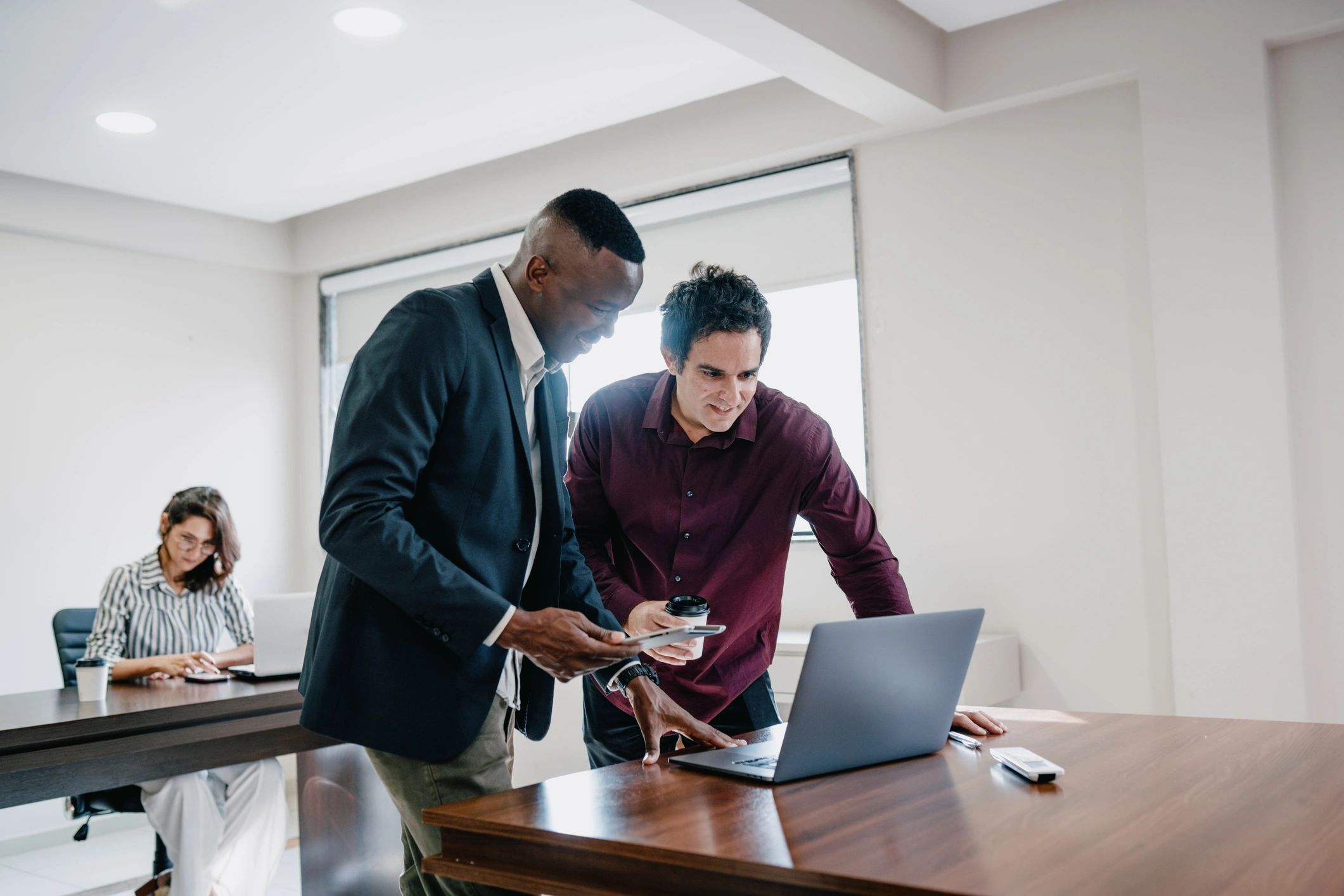 African technology professionals collaborating around a laptop in a modern office